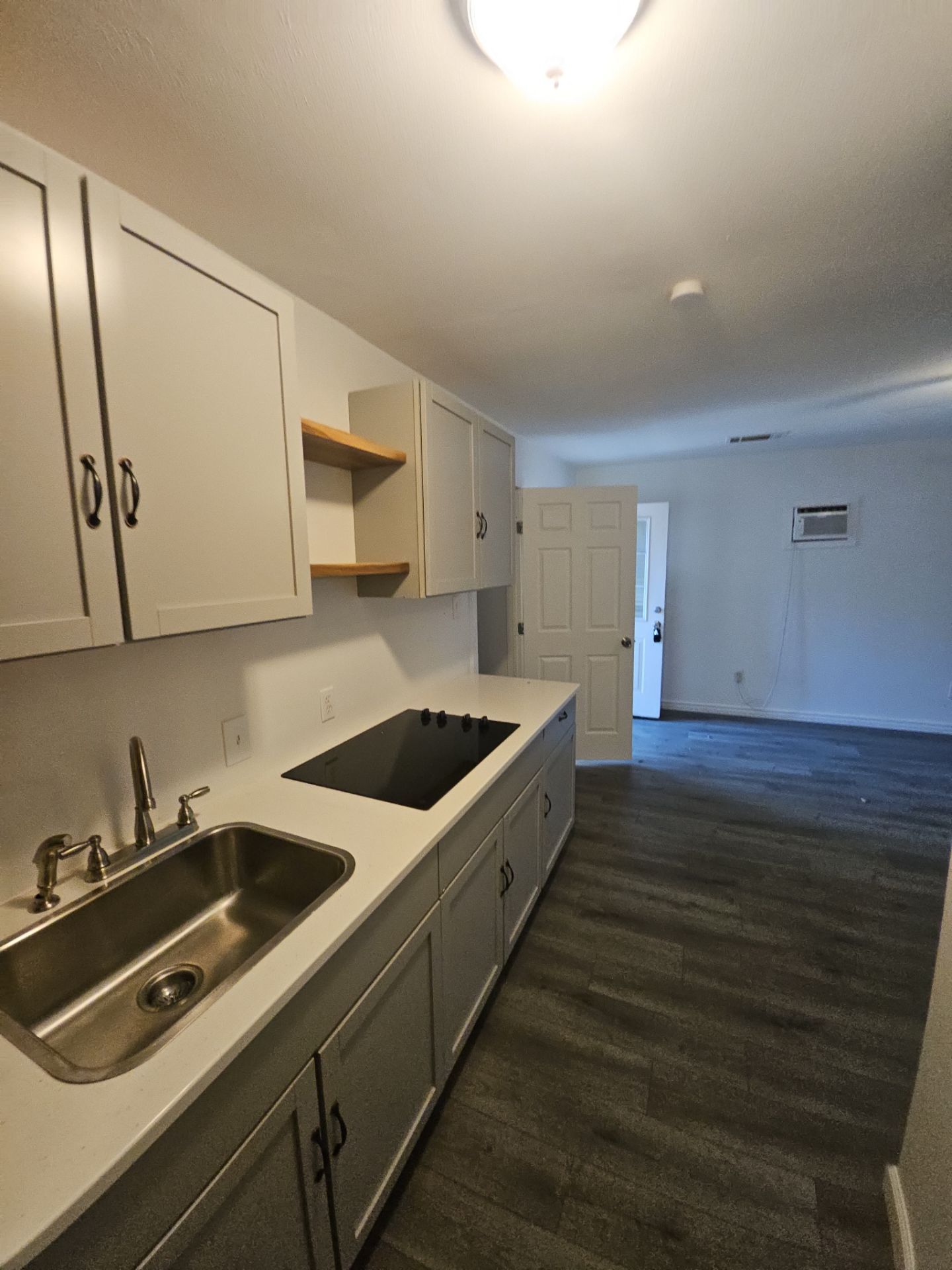 Residence C: Kitchen with gray cabinetry, sink and cooktop